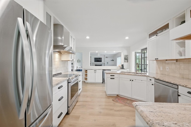 2006 Country Oaks Dr, Garland, TX 75040 - kitchen with stainless steel appliances, wall chimney range hood, a peninsula, white cabinets, and recessed lighting