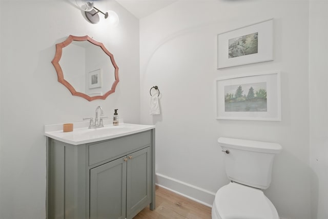 2006 Country Oaks Dr, Garland, TX 75040 - half bath featuring baseboards, vanity, wood finished floors, and toilet