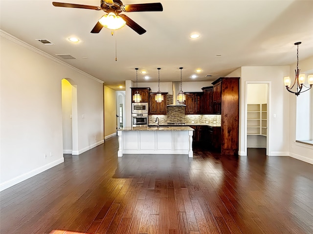 3037 Crestwater Rdg, Keller, TX 76248 - kitchen featuring stainless steel appliances, arched walkways, baseboards, an island with sink, and ornamental molding
