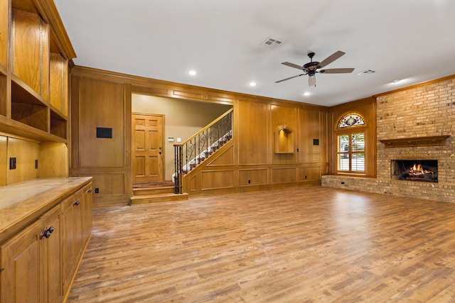 3740 Chimney Ridge Dr, Waco, TX 76708 - unfurnished living room featuring a ceiling fan, light wood-type flooring, stairway, a fireplace, and ornamental molding