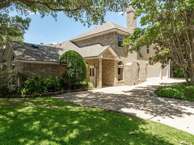 3740 Chimney Ridge Dr, Waco, TX 76708 - view of front of property featuring a front yard, an attached garage, a chimney, concrete driveway, and brick siding