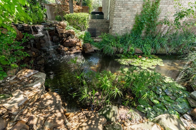 3740 Chimney Ridge Dr, Waco, TX 76708 - exterior view of a garden pond, central AC unit, and brick siding