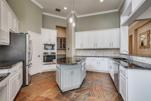 kitchen with stainless steel appliances, a sink, ornamental molding, white cabinets, and recessed lighting