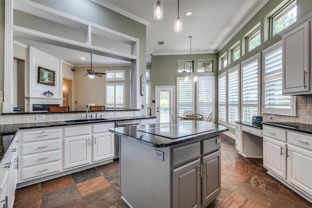 kitchen featuring a sink, crown molding, decorative backsplash, a ceiling fan, and dishwasher