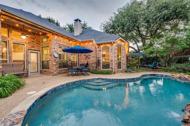 view of pool with a patio, fence, and outdoor dining area