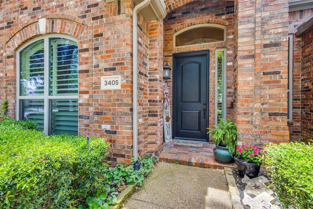 property entrance featuring brick siding