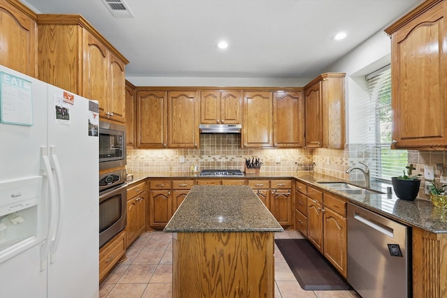 1601 Manchester Way, Corinth, TX 76210 - kitchen with appliances with stainless steel finishes, under cabinet range hood, a sink, a kitchen island, and dark stone countertops