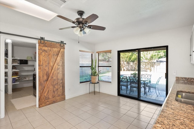 6612 Oldgate Ln, Arlington, TX 76002 - dining area with a barn door, ceiling fan, and light tile patterned floors