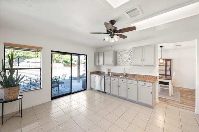6612 Oldgate Ln, Arlington, TX 76002 - kitchen with dishwasher, a sink, ceiling fan, baseboards, and light tile patterned flooring
