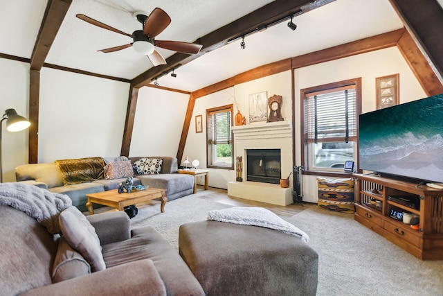 203 Goodson Way, Denton, TX 76207 - carpeted living area with track lighting, a ceiling fan, a fireplace with raised hearth, and beamed ceiling