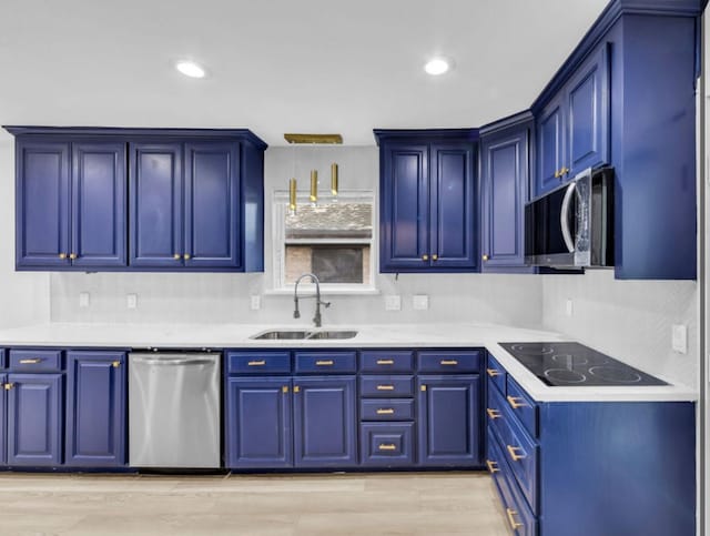 kitchen with stainless steel appliances, a sink, light countertops, tasteful backsplash, and recessed lighting