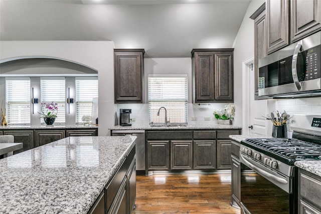 936 Mangrove Dr, Fate, TX 75087 - kitchen featuring appliances with stainless steel finishes, a sink, dark brown cabinetry, and healthy amount of natural light