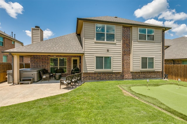 936 Mangrove Dr, Fate, TX 75087 - back of property featuring a hot tub, an area to practice putting, a patio area, brick siding, and a shingled roof