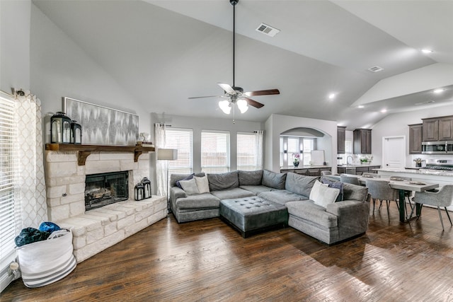 936 Mangrove Dr, Fate, TX 75087 - living area featuring lofted ceiling, a ceiling fan, a stone fireplace, and dark wood-type flooring