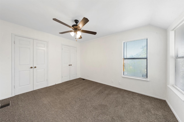 1300 Chapel Downs Rd, Waco, TX 76712 - unfurnished bedroom with multiple closets, dark colored carpet, multiple windows, ceiling fan, and lofted ceiling