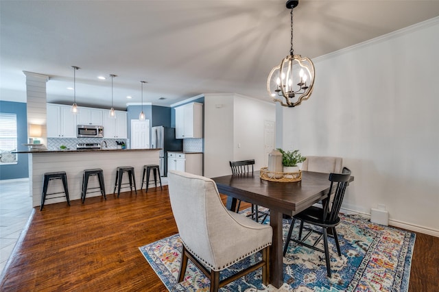 8209 Clear Bay Dr, Mckinney, TX 75072 - dining room with a chandelier, crown molding, recessed lighting, baseboards, and dark wood-type flooring
