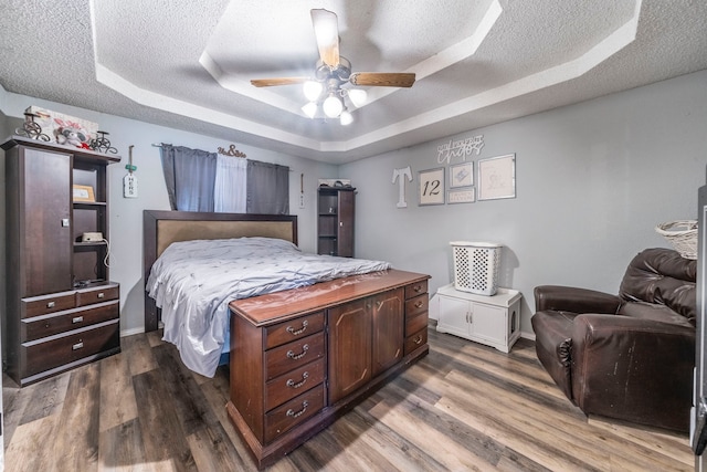 916 Rachelle Dr, Red Oak, TX 75154 - bedroom featuring a tray ceiling, a textured ceiling, wood finished floors, and baseboards