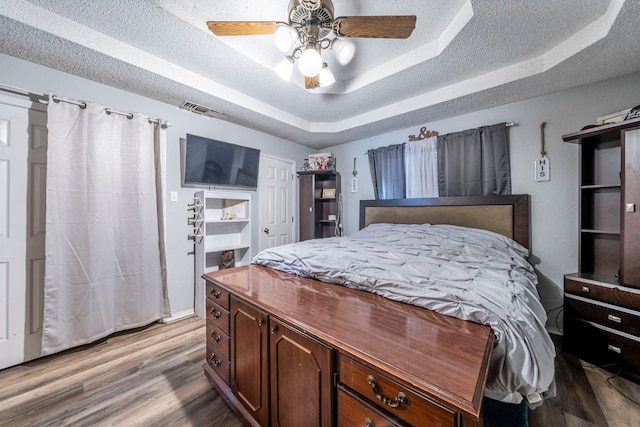 916 Rachelle Dr, Red Oak, TX 75154 - bedroom featuring a raised ceiling, light wood-type flooring, ceiling fan, and a textured ceiling