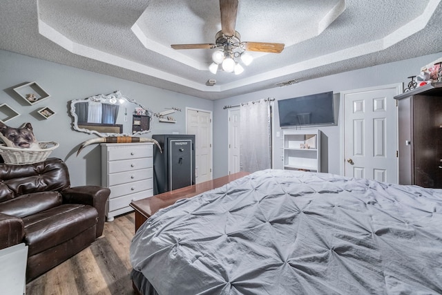 916 Rachelle Dr, Red Oak, TX 75154 - bedroom with a raised ceiling, wood finished floors, a textured ceiling, and a ceiling fan