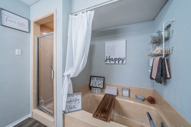 916 Rachelle Dr, Red Oak, TX 75154 - bathroom featuring a shower stall, a bath, a textured ceiling, and wood finished floors