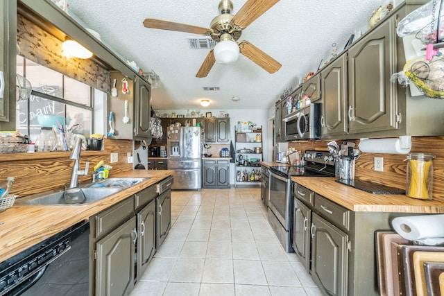 916 Rachelle Dr, Red Oak, TX 75154 - kitchen with stainless steel appliances, wooden counters, a sink, a ceiling fan, and light tile patterned floors