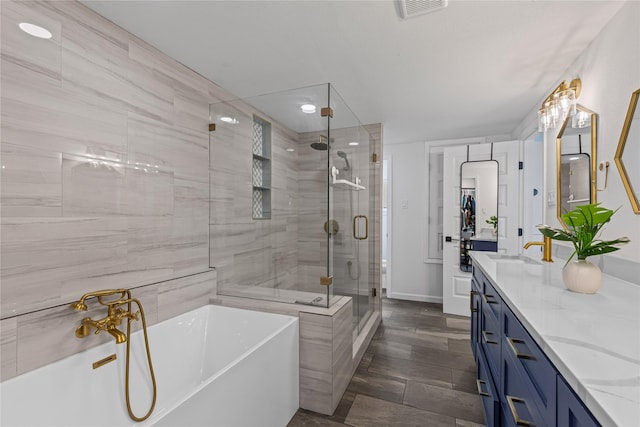 full bath with a stall shower, double vanity, and a soaking tub