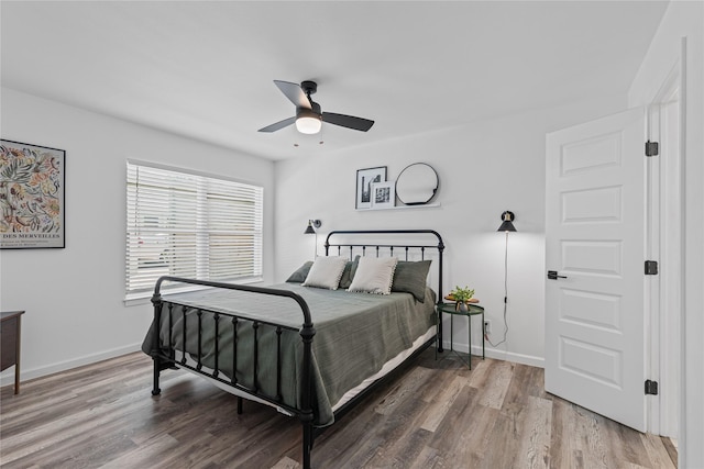bedroom with wood finished floors, baseboards, and a ceiling fan