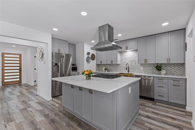 kitchen featuring gray cabinetry, island range hood, appliances with stainless steel finishes, a sink, and recessed lighting