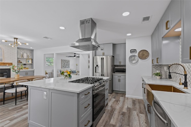 kitchen featuring gray cabinets, stainless steel appliances, island exhaust hood, decorative backsplash, and recessed lighting