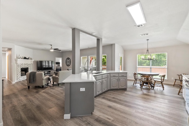 2040 Gleaner Dr, Rockwall, TX 75032 - kitchen featuring a sink, gray cabinets, wood finished floors, light countertops, and a fireplace
