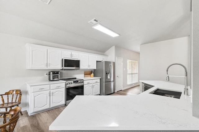 2040 Gleaner Dr, Rockwall, TX 75032 - kitchen with appliances with stainless steel finishes, a sink, light wood-style floors, and white cabinetry