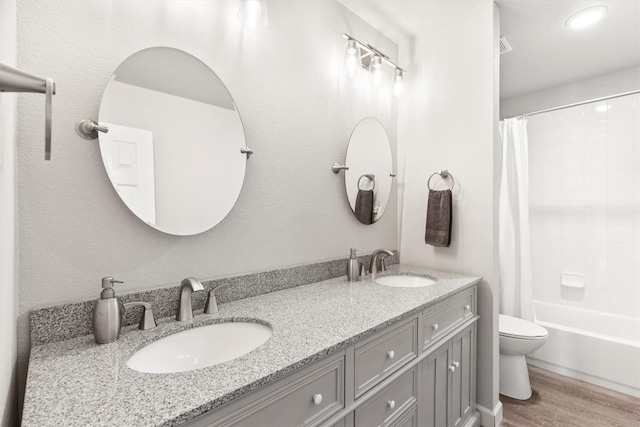 2040 Gleaner Dr, Rockwall, TX 75032 - bathroom featuring wood finished floors, double vanity, toilet, and shower / tub combo