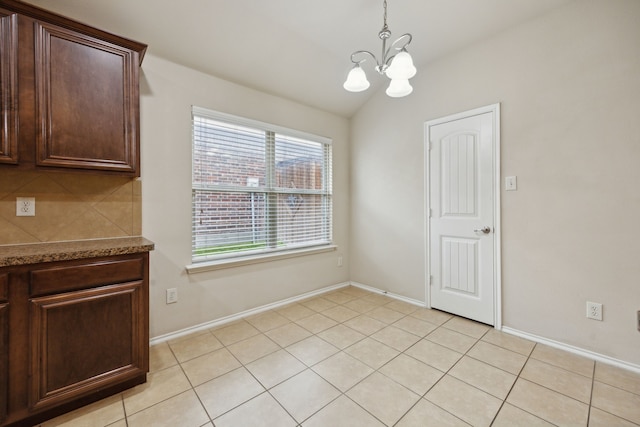 1403 Illinois Ave, Lancaster, TX 75134 - unfurnished dining area featuring a chandelier, vaulted ceiling, light tile patterned flooring, and baseboards