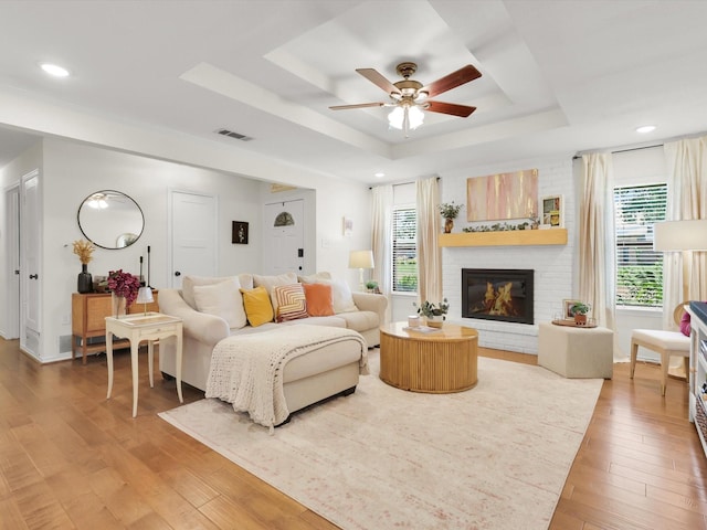 616 Stoneybrook Dr, Wylie, TX 75098 - living area featuring a tray ceiling, light wood finished floors, ceiling fan, a brick fireplace, and recessed lighting