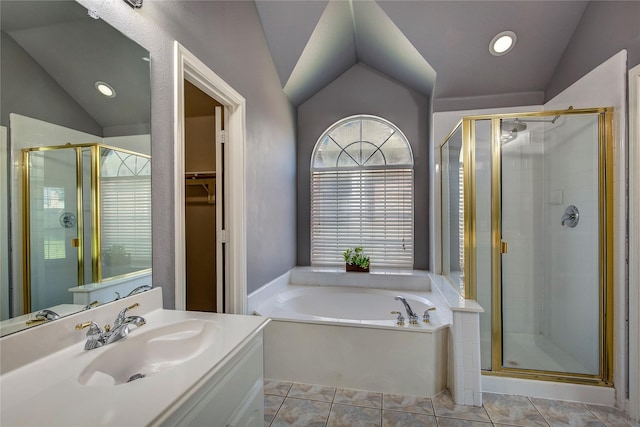 bathroom featuring lofted ceiling, a stall shower, a bath, vanity, and a walk in closet