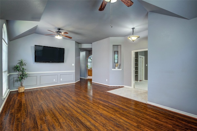 unfurnished living room with ceiling fan, wood finished floors, lofted ceiling, and baseboards