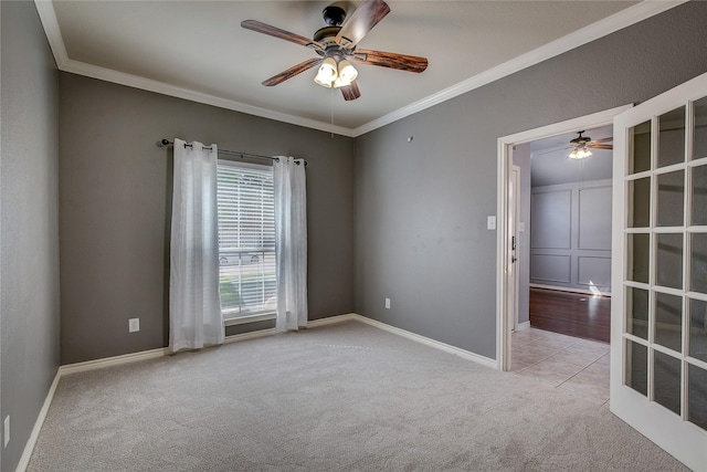 carpeted spare room with a ceiling fan, ornamental molding, and baseboards