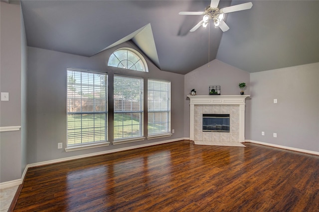unfurnished living room with wood finished floors, a ceiling fan, lofted ceiling, a fireplace, and baseboards