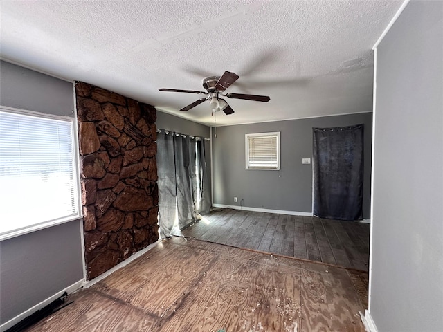 4320 Comanche Dr, May, TX 76857 - spare room with wood-type flooring, a ceiling fan, baseboards, and a textured ceiling