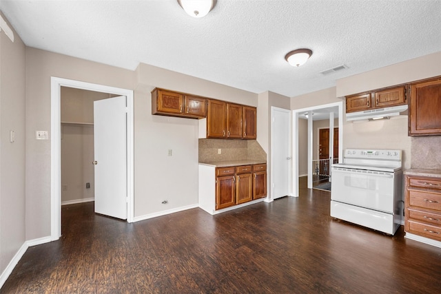 444 Lindenwood Ln W, Hewitt, TX 76643 - kitchen with white range with electric cooktop, under cabinet range hood, dark wood-style flooring, brown cabinets, and backsplash