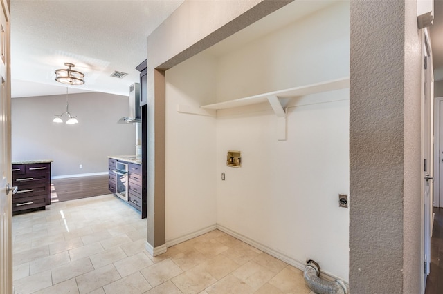 3604 Windsong Ln, Bedford, TX 76021 - laundry area with hookup for an electric dryer, washer hookup, baseboards, and a chandelier