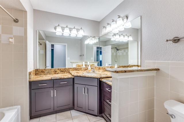 3604 Windsong Ln, Bedford, TX 76021 - bathroom featuring a tile shower, tile patterned floors, toilet, vanity, and tile walls