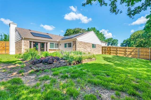 3604 Windsong Ln, Bedford, TX 76021 - back of property featuring brick siding, roof mounted solar panels, and a chimney