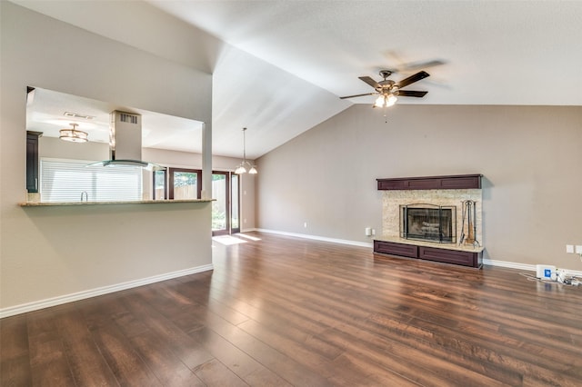 3604 Windsong Ln, Bedford, TX 76021 - unfurnished living room with ceiling fan, dark wood-style flooring, vaulted ceiling, a stone fireplace, and baseboards