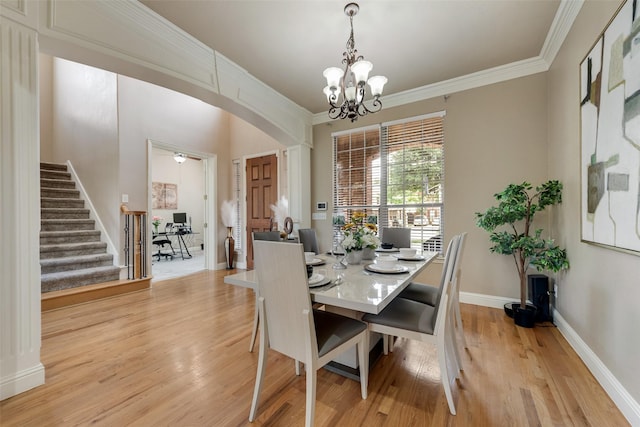 15606 Fox Meadow Ln, Frisco, TX 75035 - dining area with arched walkways, a chandelier, light wood finished floors, stairs, and ornamental molding