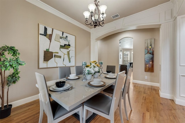 15606 Fox Meadow Ln, Frisco, TX 75035 - dining area with arched walkways, light wood-type flooring, a chandelier, baseboards, and ornamental molding