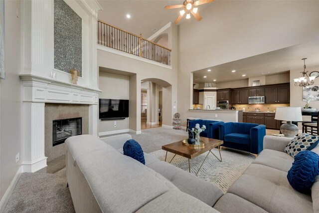 15606 Fox Meadow Ln, Frisco, TX 75035 - living room featuring arched walkways, a ceiling fan, light colored carpet, baseboards, and a tiled fireplace