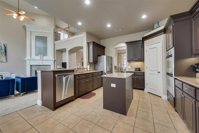 15606 Fox Meadow Ln, Frisco, TX 75035 - kitchen featuring appliances with stainless steel finishes, a sink, arched walkways, ceiling fan, and open floor plan
