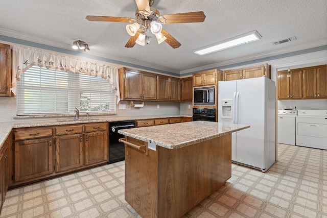 122 Clearview Ln, Fort Worth, TX 76126 - kitchen with black appliances, separate washer and dryer, light floors, a center island, and a textured ceiling