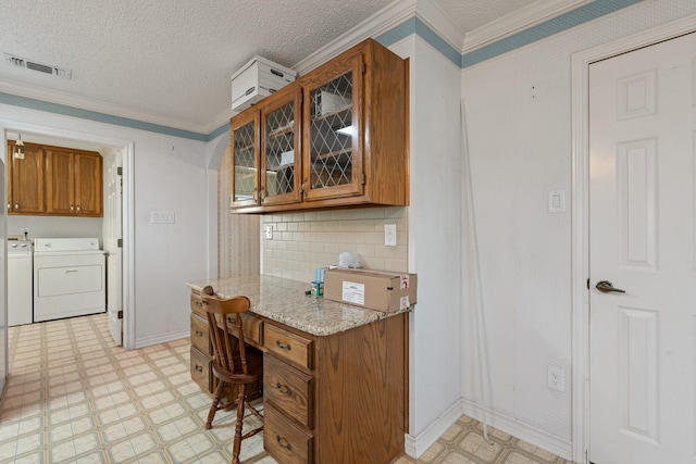 122 Clearview Ln, Fort Worth, TX 76126 - kitchen with brown cabinetry, light flooring, separate washer and dryer, crown molding, and a textured ceiling